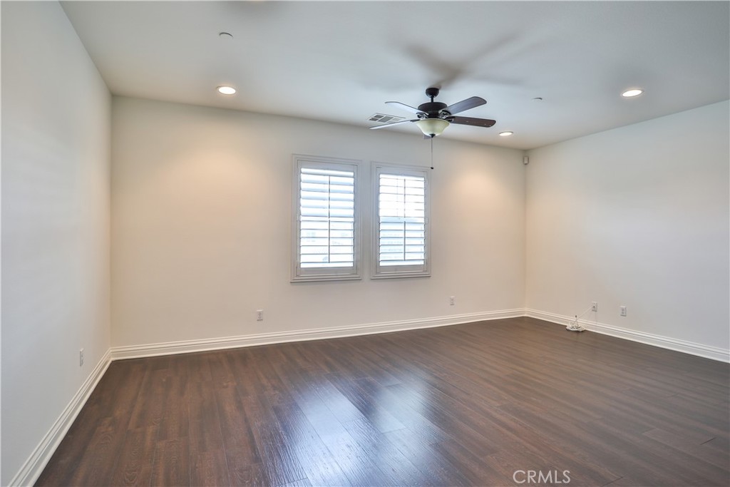 2795 Devonshire Lane Ontario, CA 91762 - Photo 36 of 50 an empty room with wooden floor ceiling fan and windows