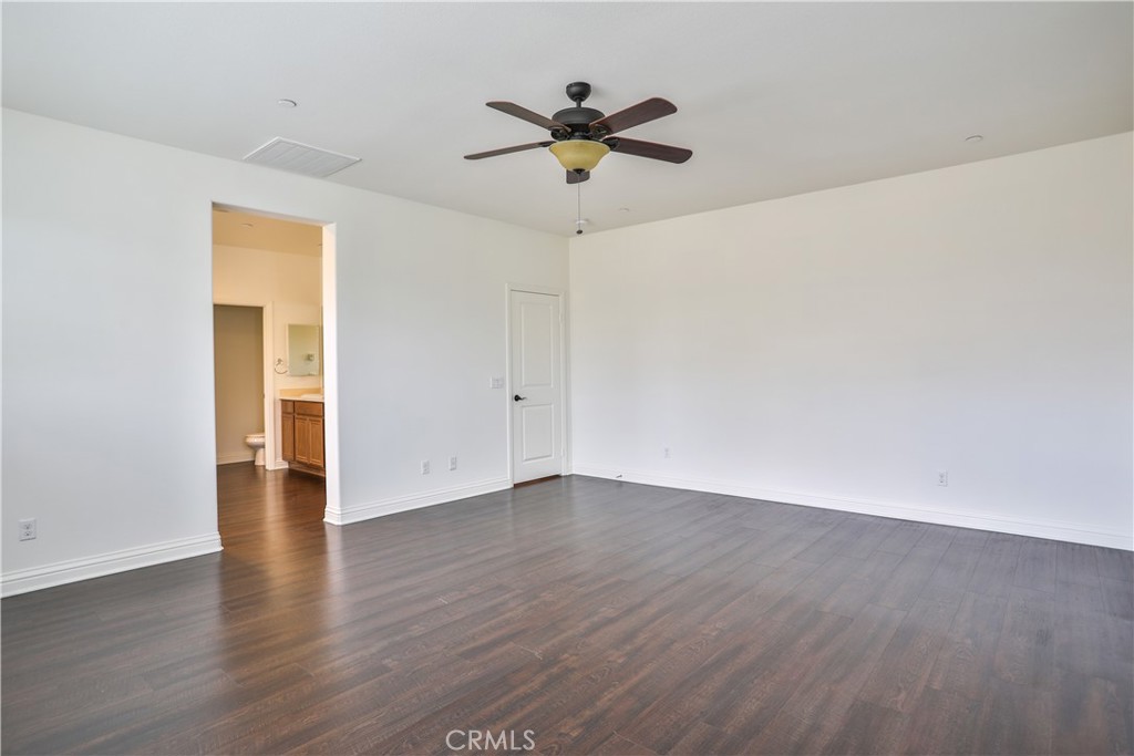 2795 Devonshire Lane Ontario, CA 91762 - Photo 39 of 50 a view of an empty room with wooden floor and a ceiling fan