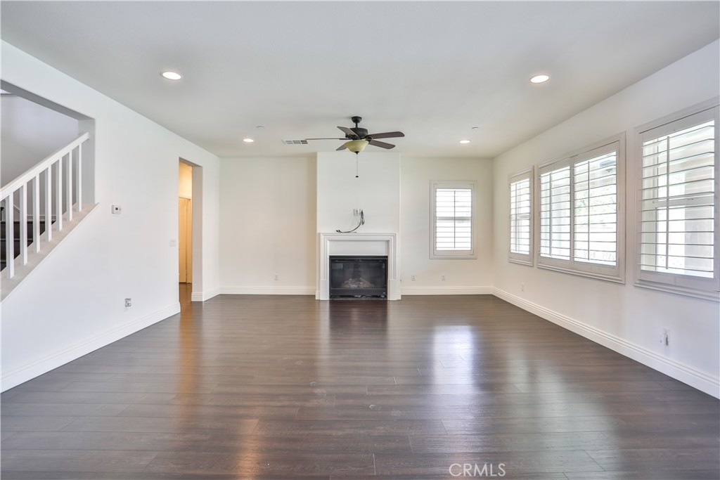 2795 Devonshire Lane Ontario, CA 91762 - Photo 10 of 50 an empty room with wooden floor fireplace and windows