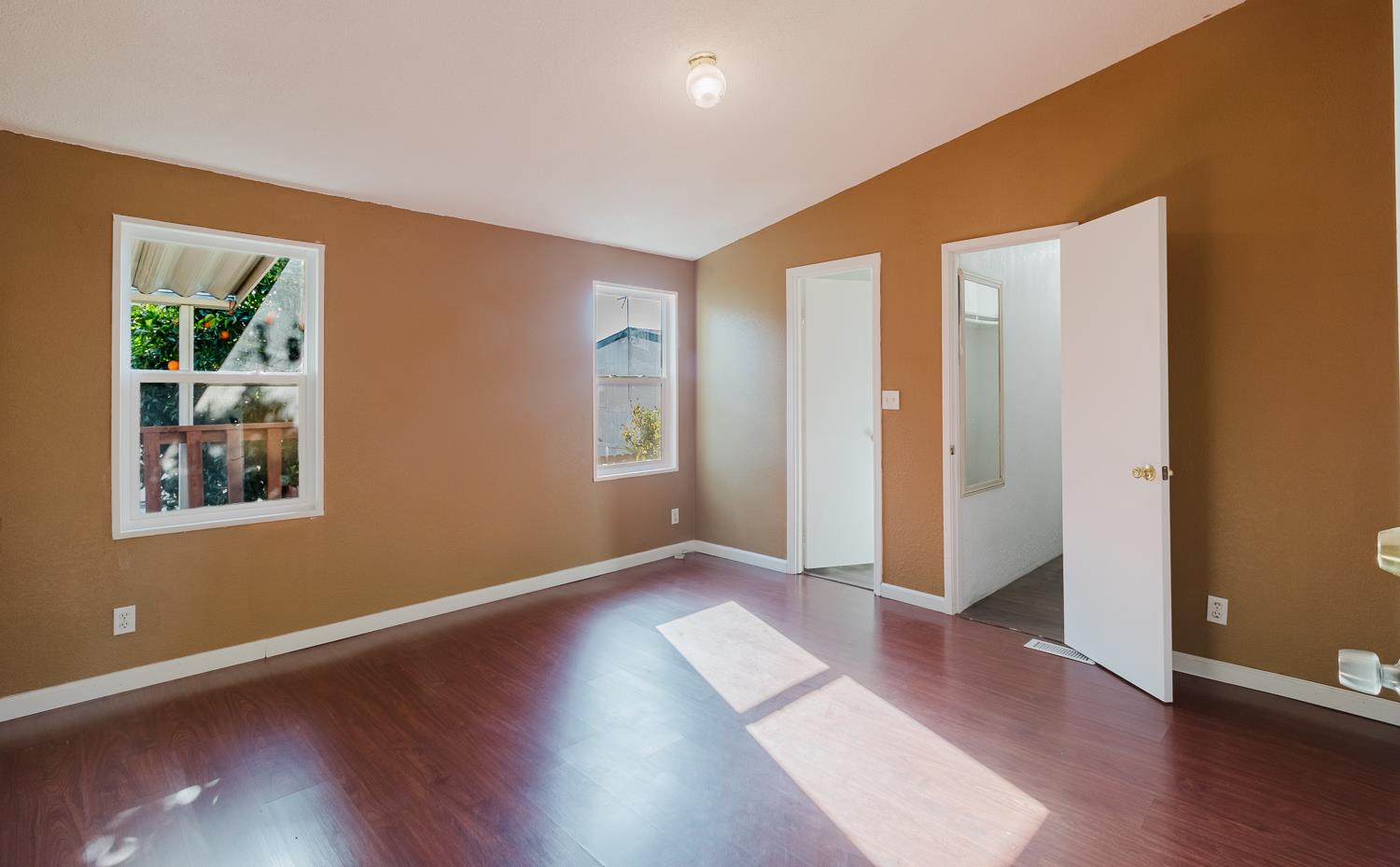 216 California Loop Sacramento, CA 95823 - Photo 15 of 42 an empty room with wooden floor and windows
