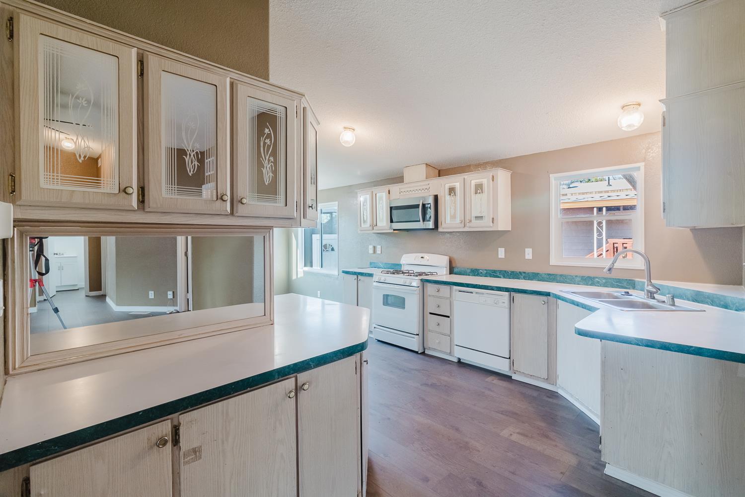 216 California Loop Sacramento, CA 95823 - Photo 21 of 42 a kitchen with stainless steel appliances granite countertop a sink and cabinets with wooden floor
