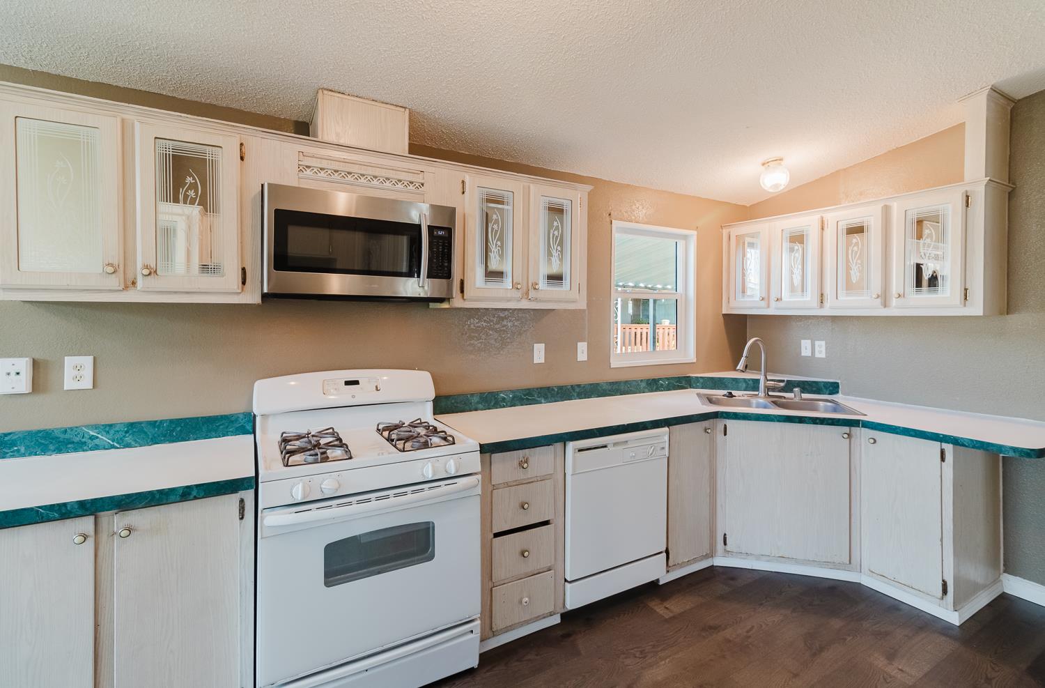 216 California Loop Sacramento, CA 95823 - Photo 26 of 42 a kitchen with granite countertop white cabinets and white appliances