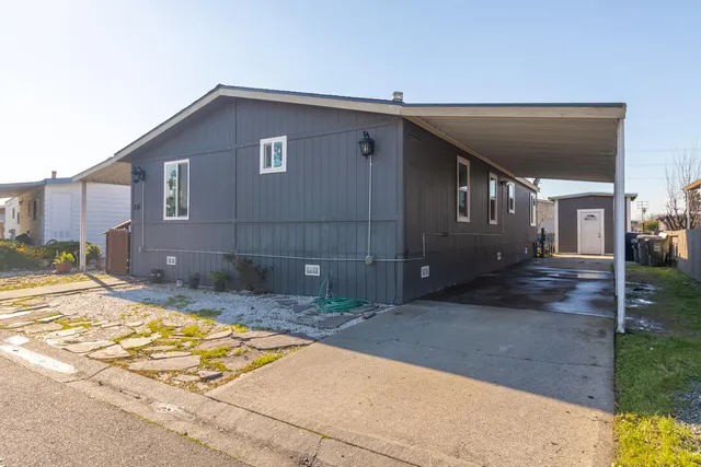 a view of a house with backyard and sitting area