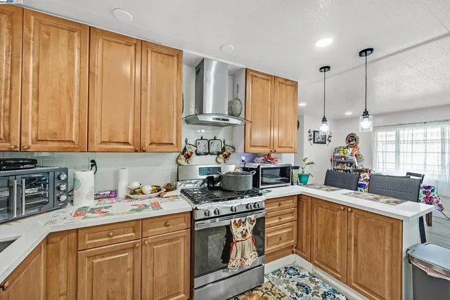 a kitchen with stainless steel appliances a stove a sink a cabinets and wooden floor