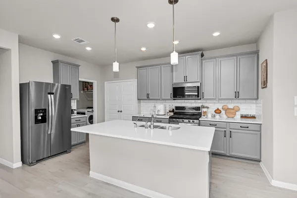 a kitchen with stainless steel appliances a refrigerator sink and microwave