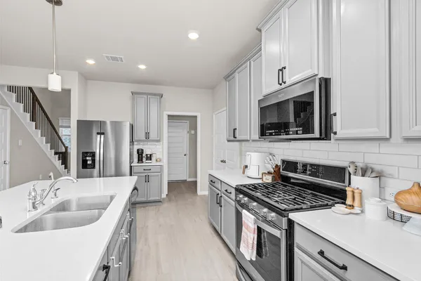 a kitchen with stainless steel appliances granite countertop a sink stove and refrigerator