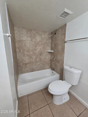 a white toilet sitting next to a bath tub and a shower