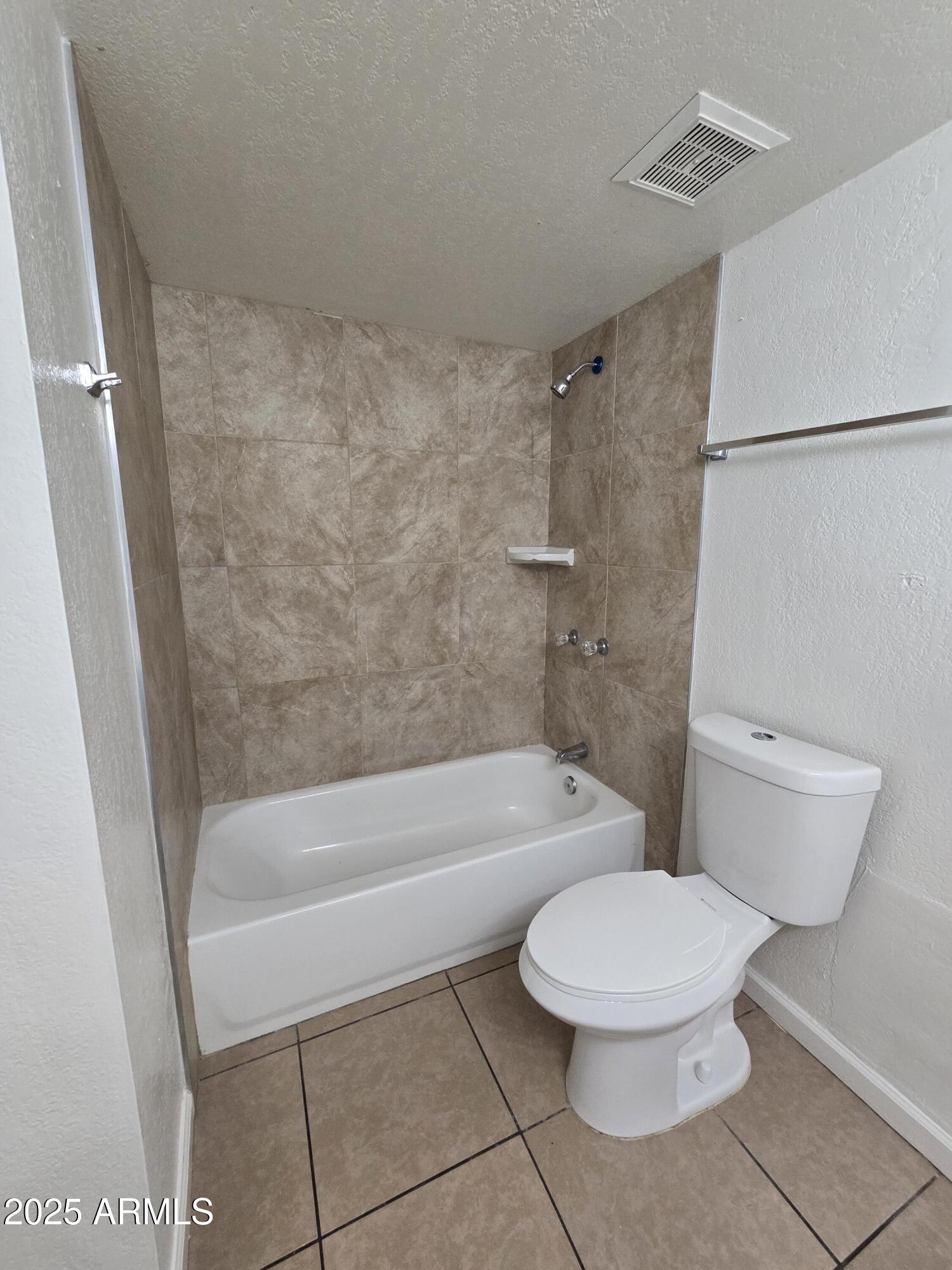 7752 West Flower Street Phoenix, AZ 85033 - Photo 15 of 30 a white toilet sitting next to a bath tub and a shower
