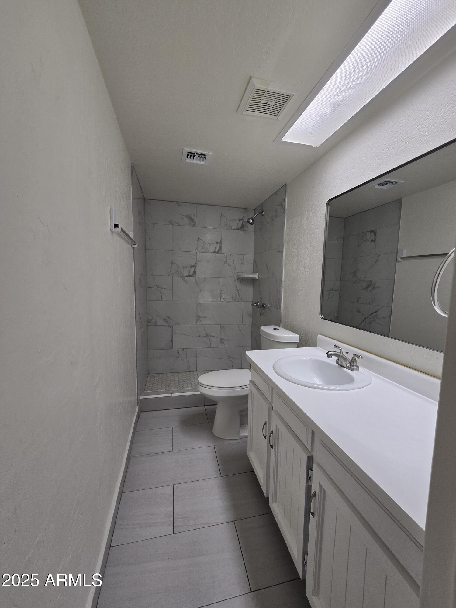 7752 West Flower Street Phoenix, AZ 85033 - Photo 19 of 30 a bathroom with a sink a toilet and a large mirror