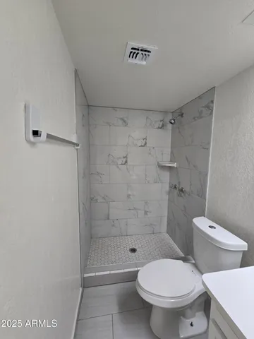 a white toilet sitting next to a bath tub