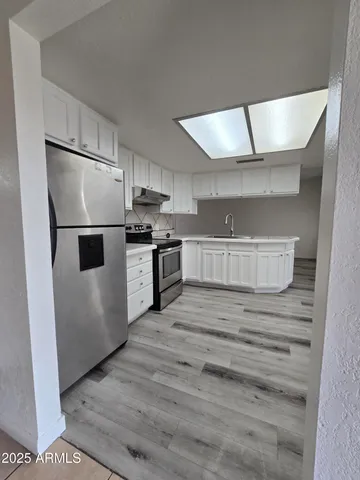 a kitchen with stainless steel appliances granite countertop a refrigerator and a stove