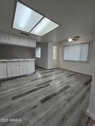 an empty room with wooden floor and cabinet
