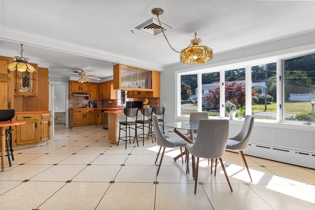 63 Sears Road Milton, MA 02186 - Photo 12 of 42 a view of a dining room with furniture large windows and a chandelier