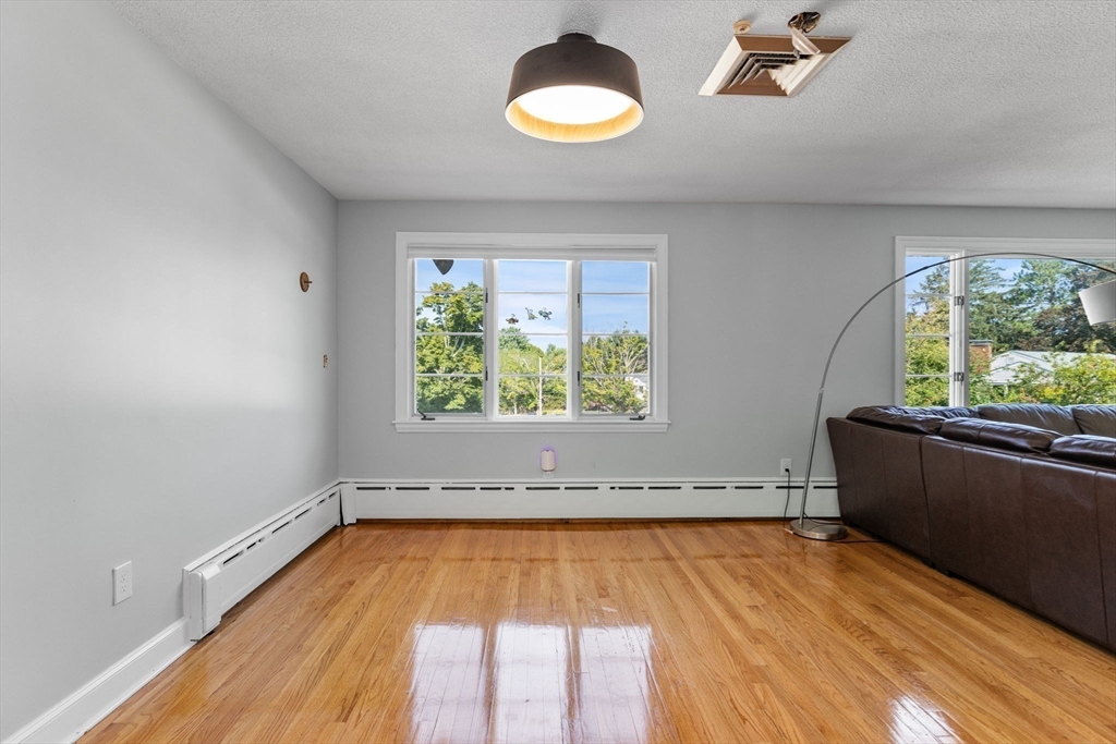 63 Sears Road Milton, MA 02186 - Photo 17 of 42 wooden floor in an empty room with a window