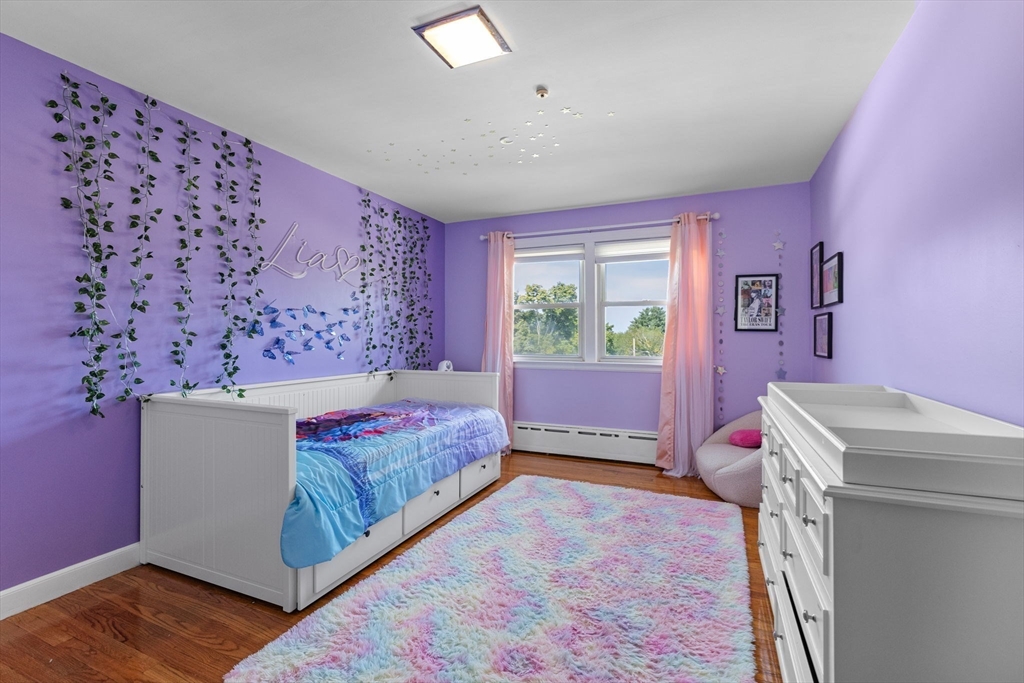 63 Sears Road Milton, MA 02186 - Photo 18 of 42 a spacious bedroom with a bed and a table