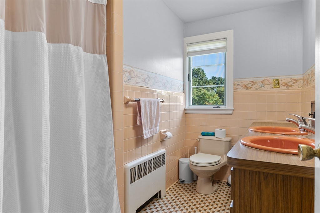 63 Sears Road Milton, MA 02186 - Photo 28 of 42 a bathroom with a toilet a sink and a window