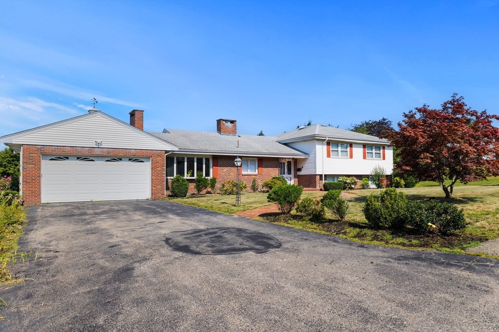 63 Sears Road Milton, MA 02186 - Photo 3 of 42 a front view of a house with a yard and garage