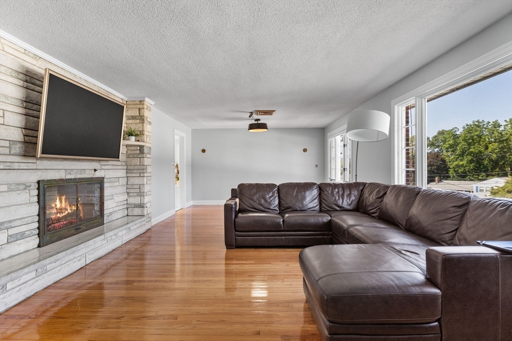 63 Sears Road Milton, MA 02186 - Photo 4 of 42 a living room with furniture a flat screen tv and a fireplace