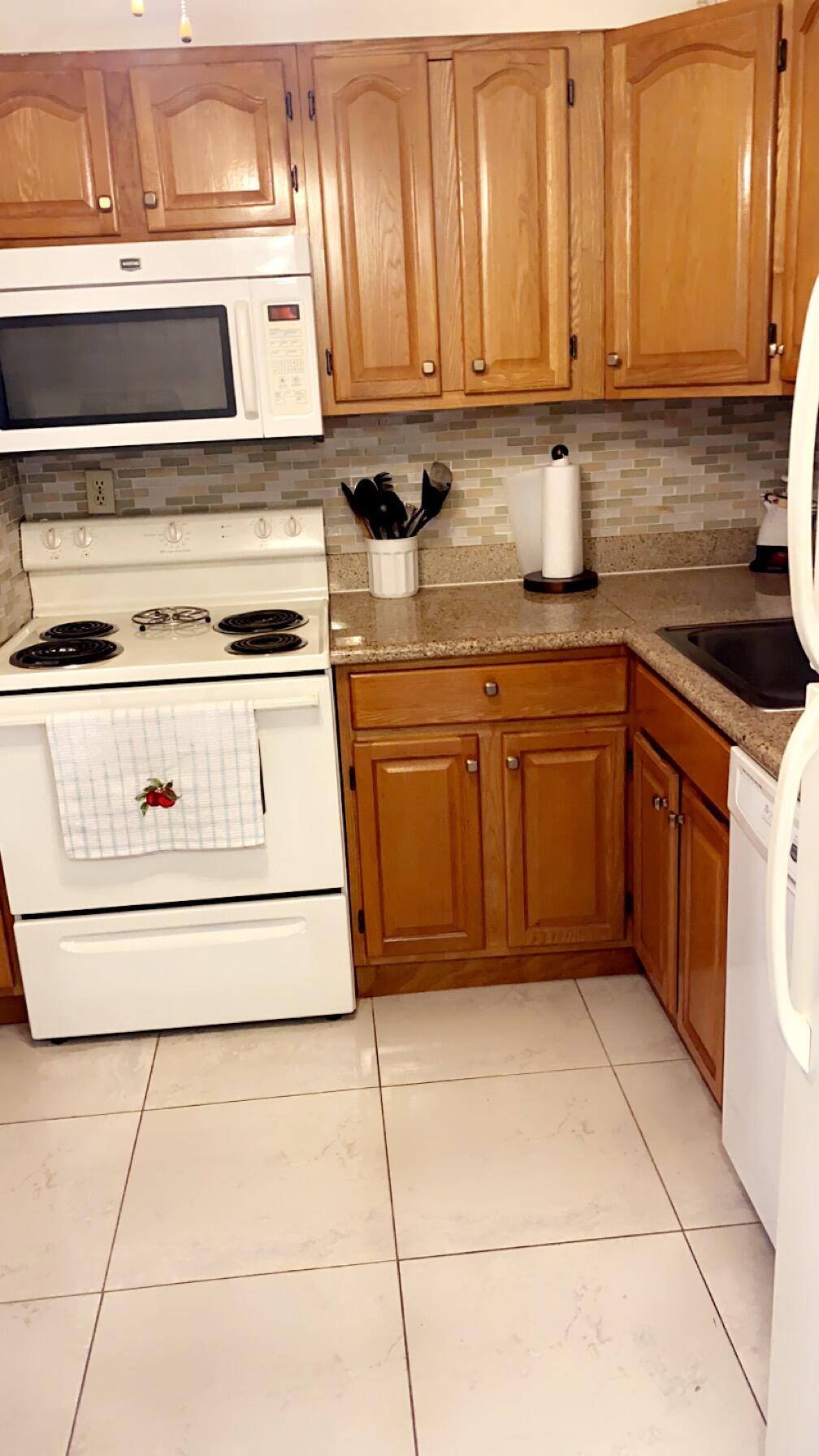 3000 Northwest 48th Terrace, Unit 422 Lauderdale Lakes, FL 33313 - Photo 3 of 9 a kitchen with stainless steel appliances granite countertop a stove a sink and a refrigerator