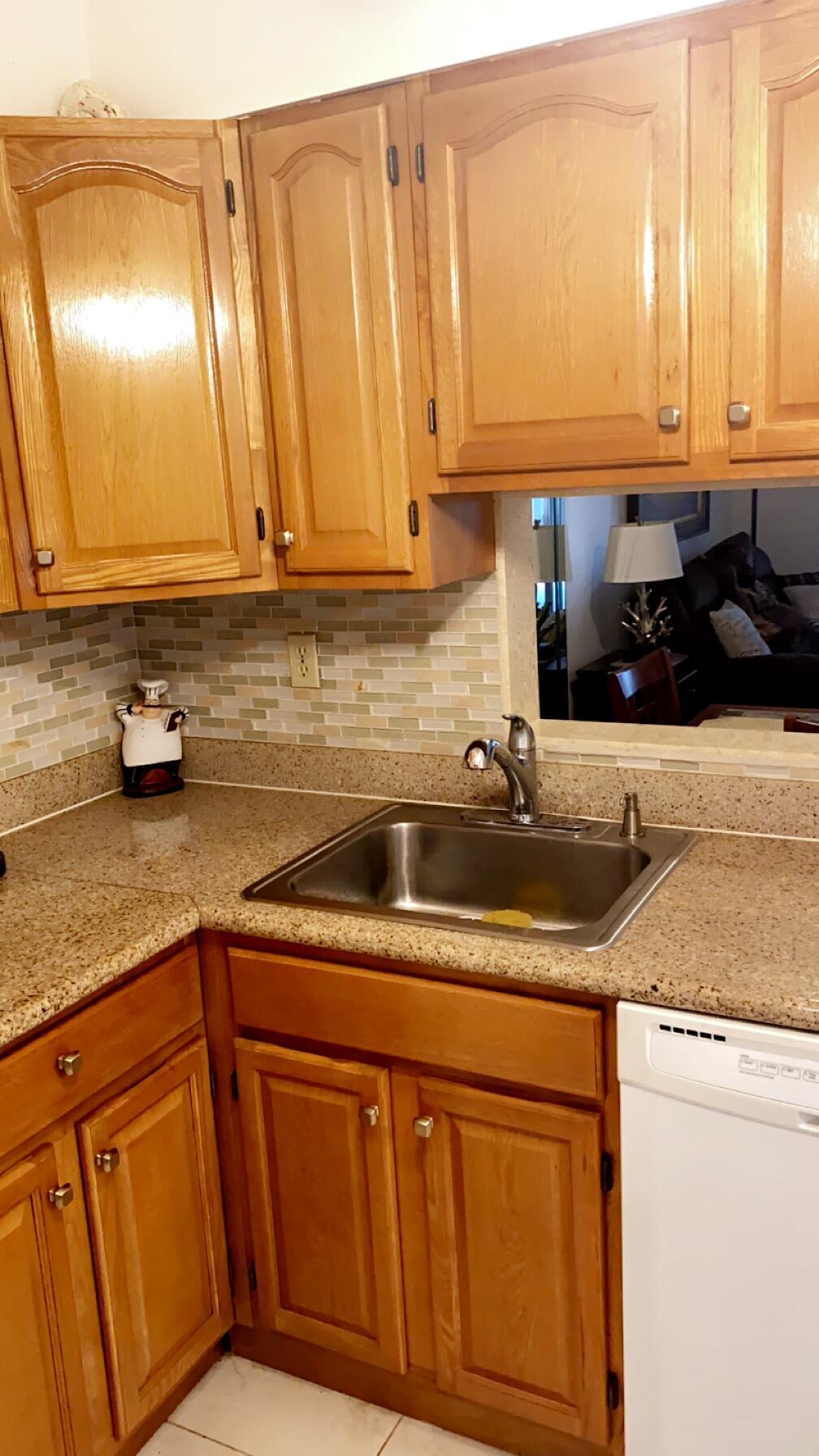 3000 Northwest 48th Terrace, Unit 422 Lauderdale Lakes, FL 33313 - Photo 4 of 9 a kitchen with stainless steel appliances granite countertop a sink a stove white cabinets and a sink