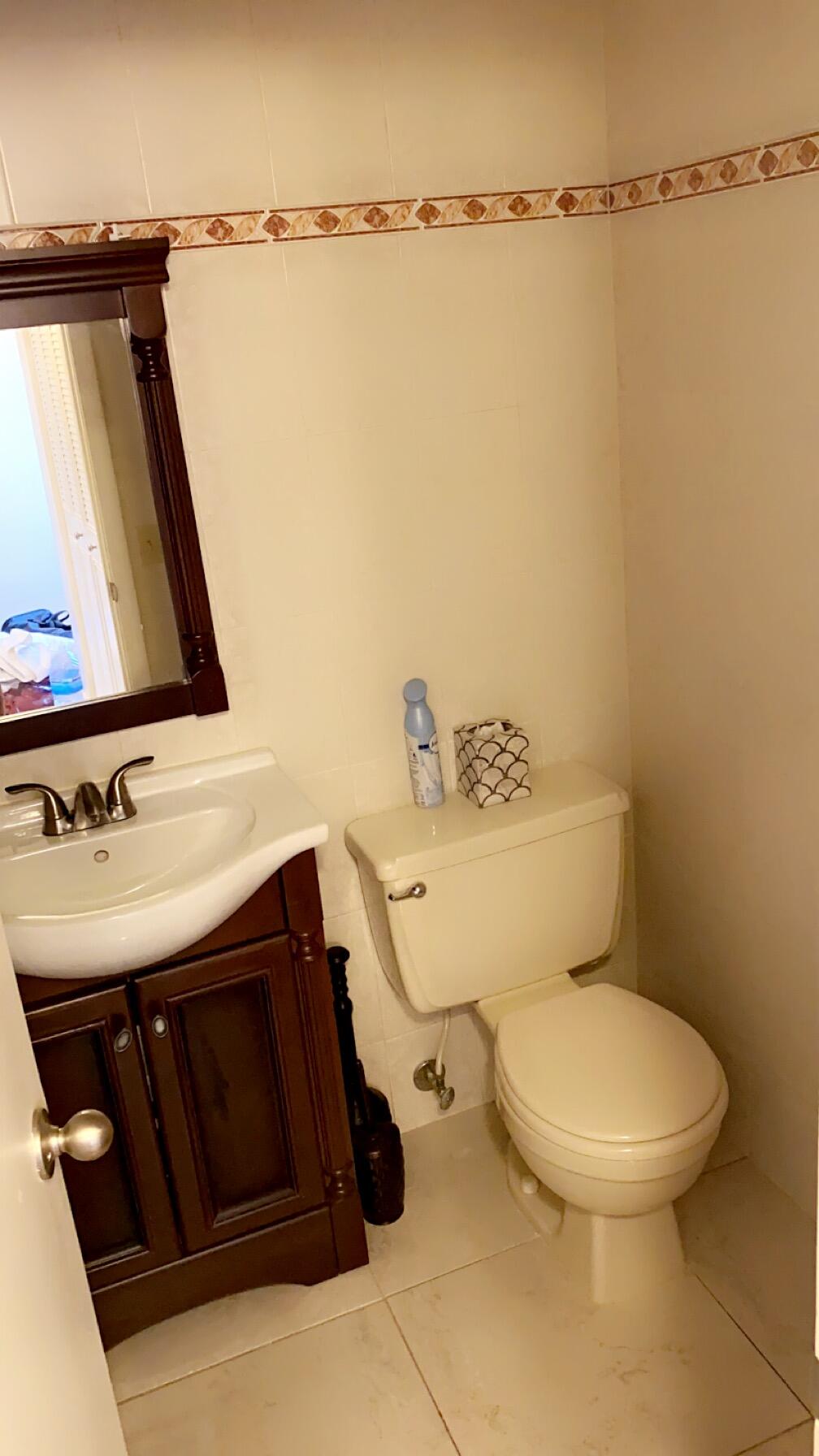 3000 Northwest 48th Terrace, Unit 422 Lauderdale Lakes, FL 33313 - Photo 8 of 9 a bathroom with a sink a toilet and a mirror