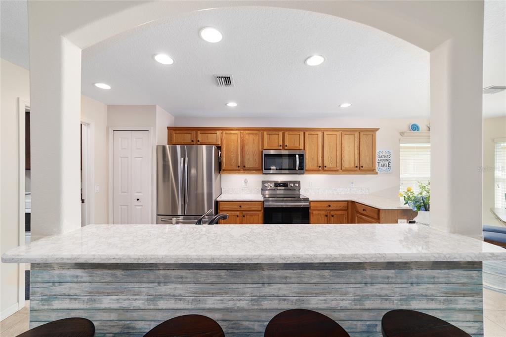 1056 Southwest 159th Street Ocala, FL 34473 - Photo 12 of 45 a kitchen with stainless steel appliances granite countertop a sink a stove and a refrigerator