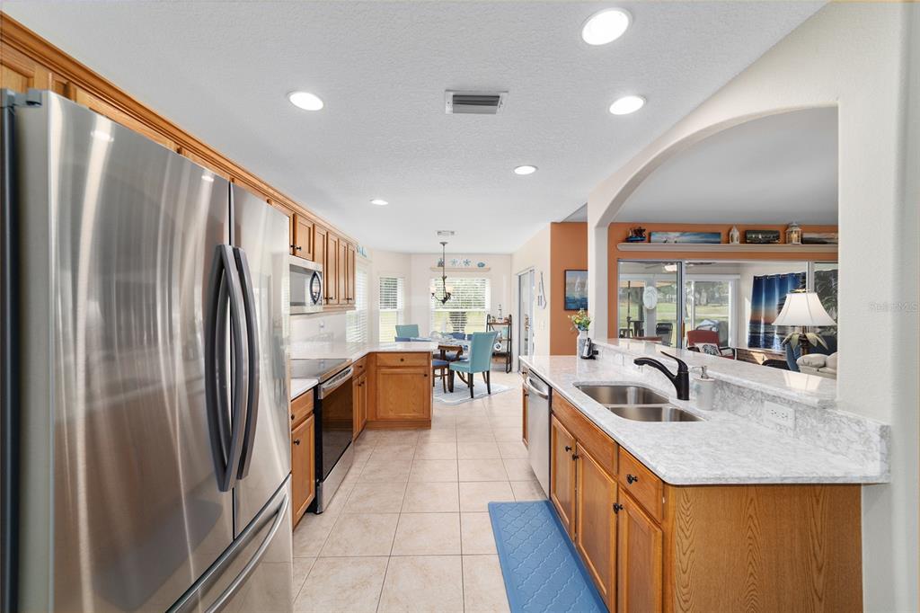 1056 Southwest 159th Street Ocala, FL 34473 - Photo 14 of 45 a kitchen with stainless steel appliances granite countertop a refrigerator a sink a stove and a refrigerator