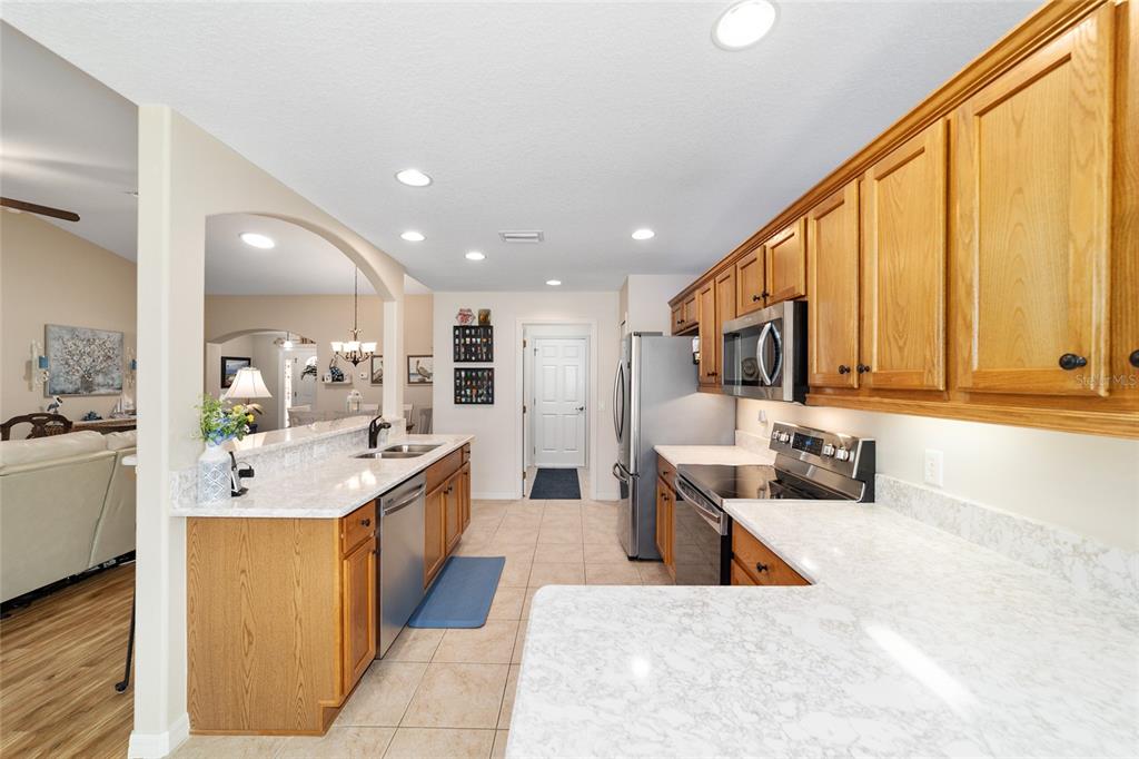 1056 Southwest 159th Street Ocala, FL 34473 - Photo 15 of 45 a large kitchen with stainless steel appliances kitchen island a large counter top a stove and a sink