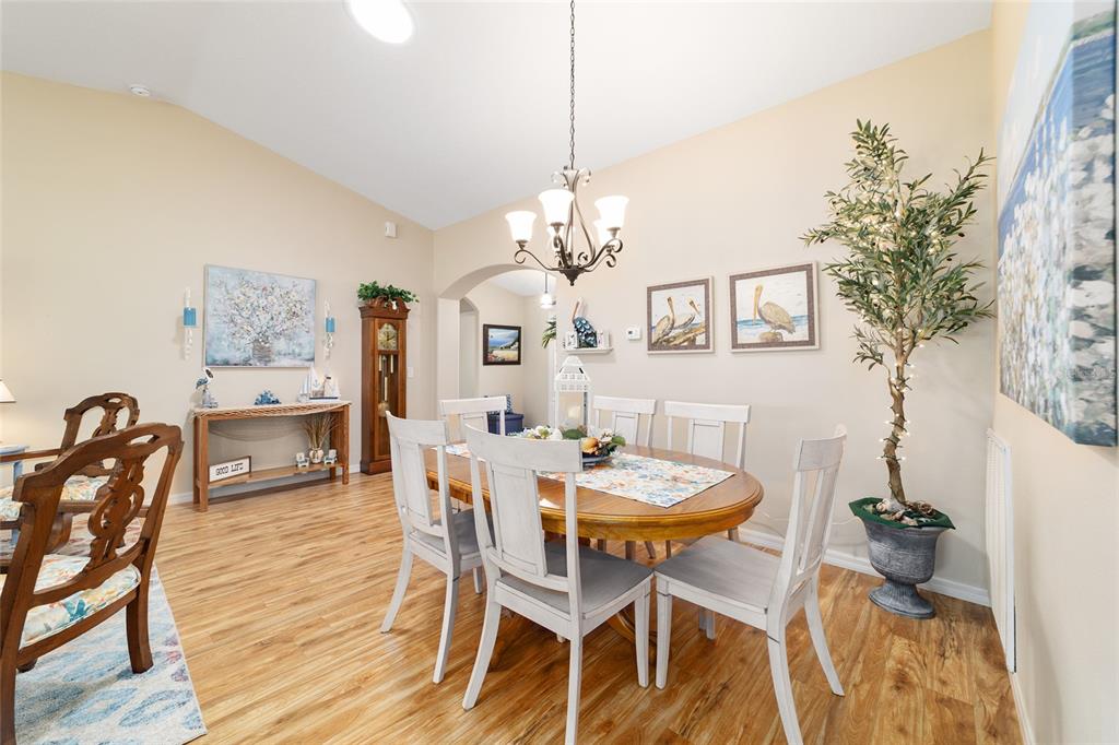 1056 Southwest 159th Street Ocala, FL 34473 - Photo 10 of 45 a dining room with furniture a chandelier and wooden floor
