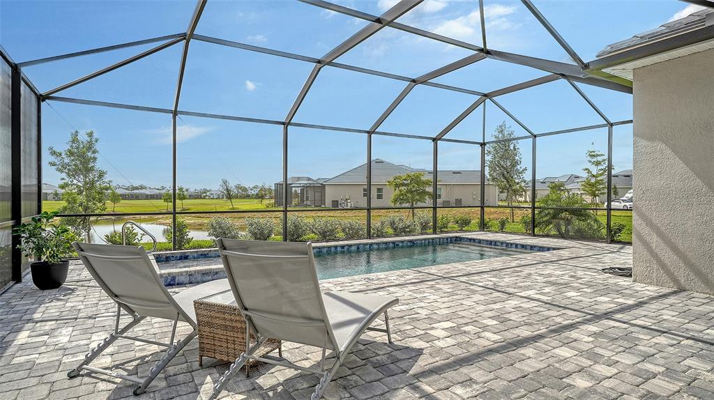 12716 Tulum Loop Venice, FL 34293 - Photo 38 of 97 a view of a patio with a table chairs and a floor to ceiling window