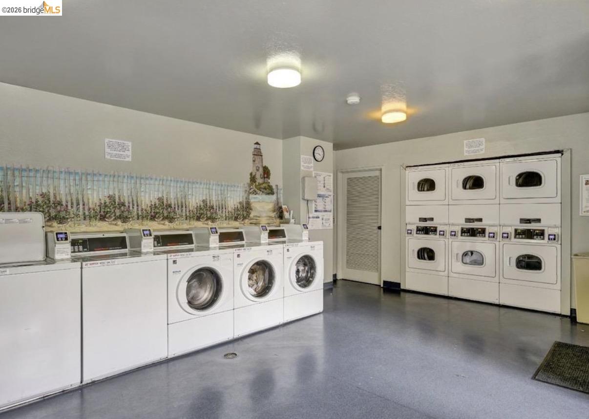 7 Embarcadero, Unit 204 Oakland, CA 94607 - Photo 22 of 27 Communal laundry room with washer and clothes dryer and stacked washer and dryer