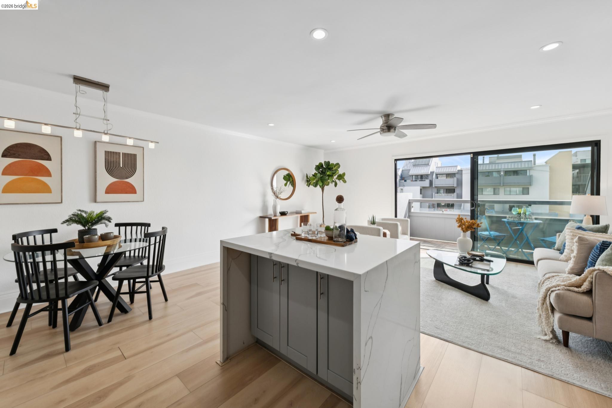 7 Embarcadero, Unit 204 Oakland, CA 94607 - Photo 27 of 27 Kitchen with decorative light fixtures, gray cabinetry, light wood-style flooring, light stone counters, and open floor plan