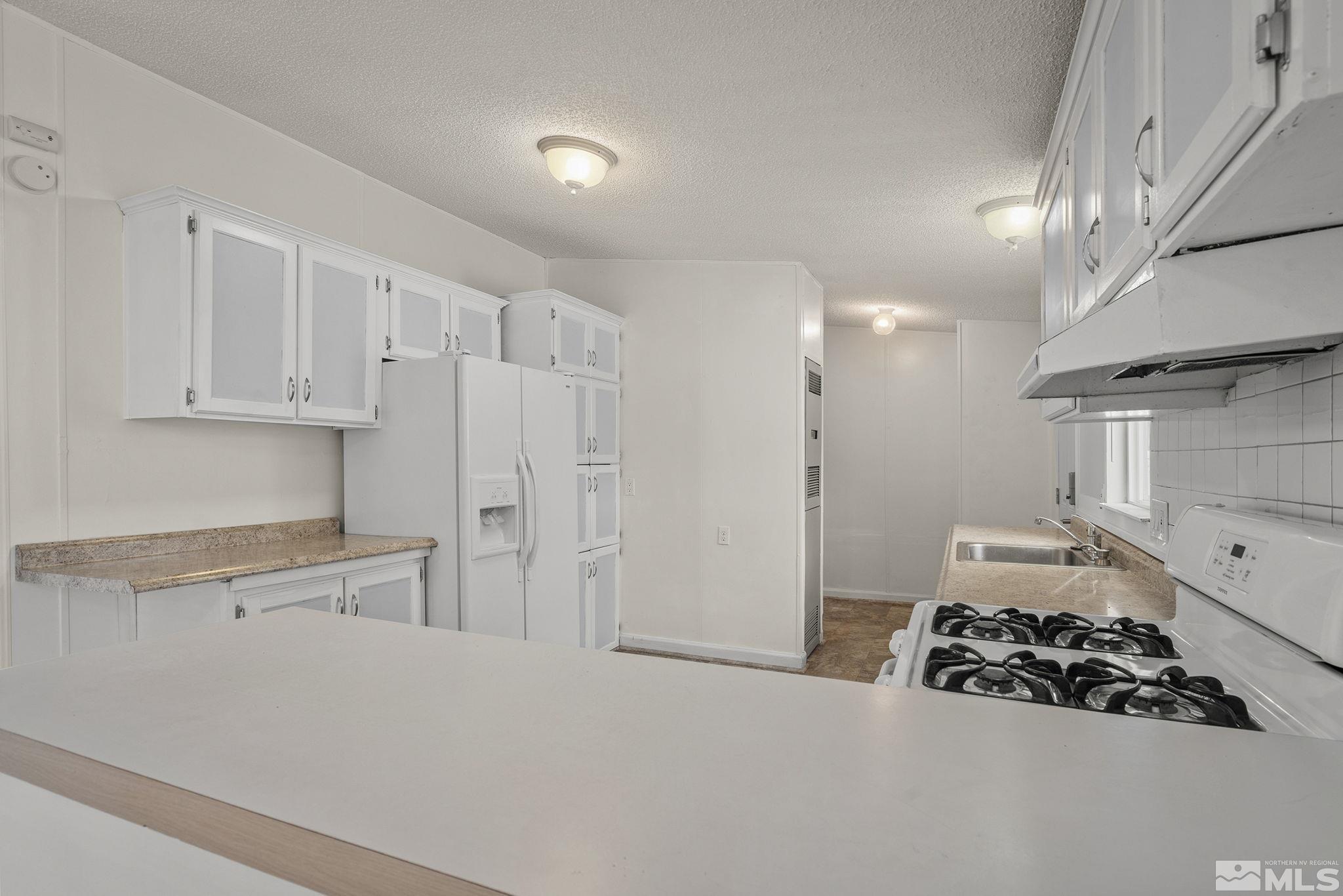 1815 Collins Circle Reno, NV 89506 - Photo 16 of 40 a kitchen with white cabinets and stove