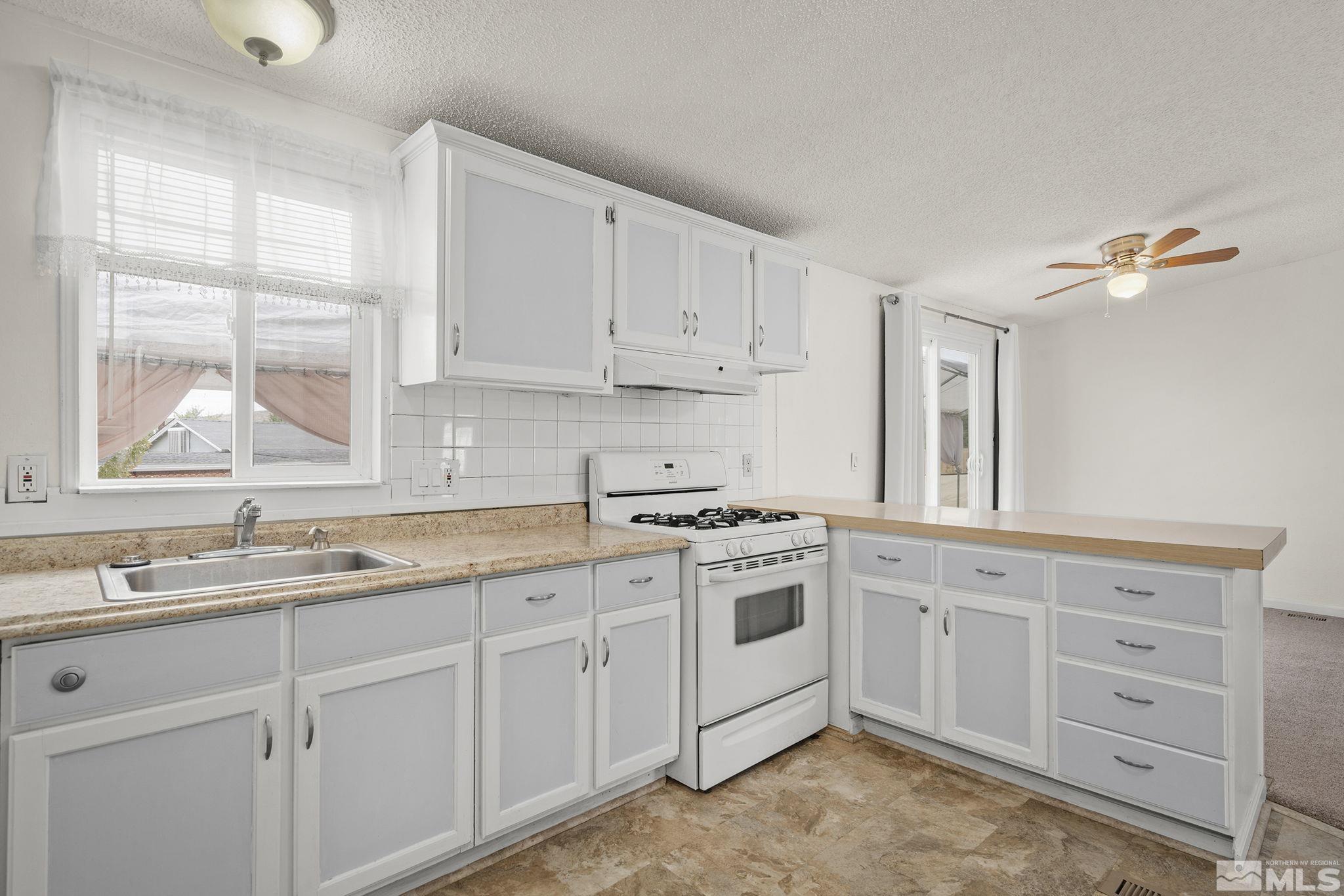 1815 Collins Circle Reno, NV 89506 - Photo 18 of 40 a kitchen with granite countertop a sink a stove and cabinets