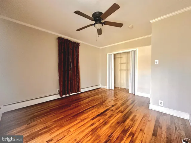 a view of room with wooden floor and ceiling fan