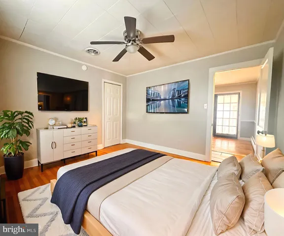 a bedroom with a bed a flat screen tv and a couch