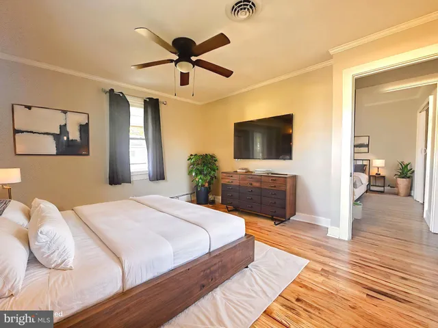 a spacious bedroom with a bed and a flat screen tv