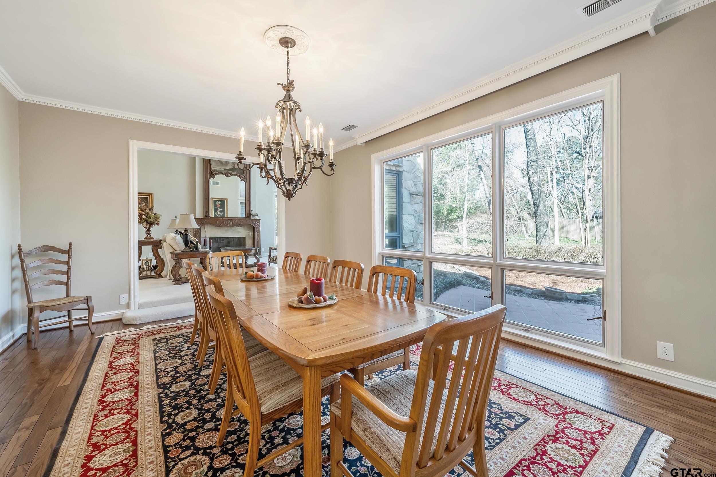 628 Wilder Way Tyler, TX 75703 - Photo 15 of 46 a dining room with wooden floor a chandelier a wooden table and chairs