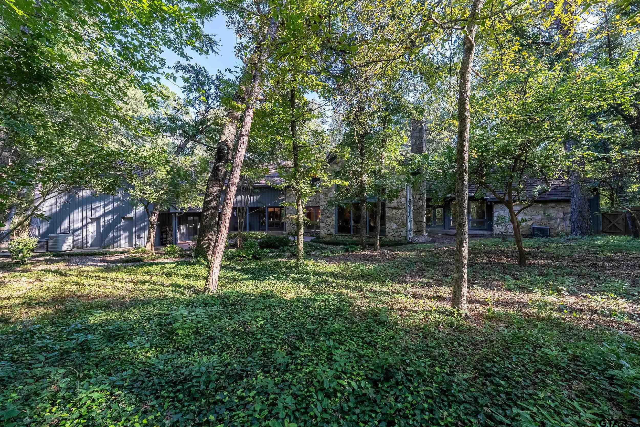 628 Wilder Way Tyler, TX 75703 - Photo 27 of 46 a backyard of a house with plants and large trees