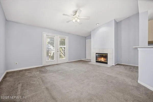 an empty room with windows and fireplace