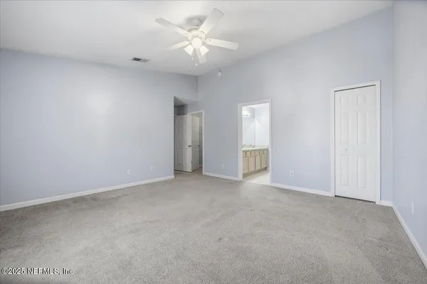 a view of an empty room with a ceiling fan
