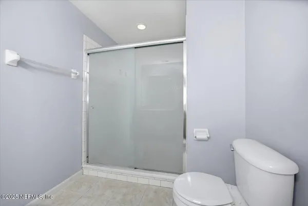 a white toilet sitting next to a shower