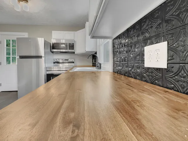 a open kitchen with stainless steel appliances a refrigerator sink and microwave