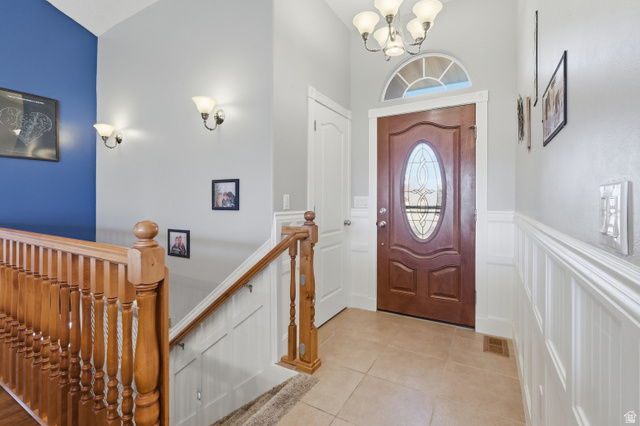 860 West 2980th Street South Logan, UT 84321 - Photo 4 of 38 Foyer featuring a wood-finish entry door with an oval leaded glass insert, an arched transom window, and tiled flooring