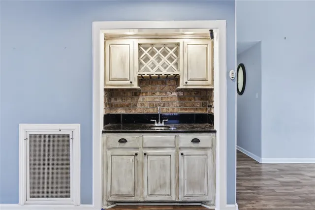 a hallway with wooden floor table and chairs