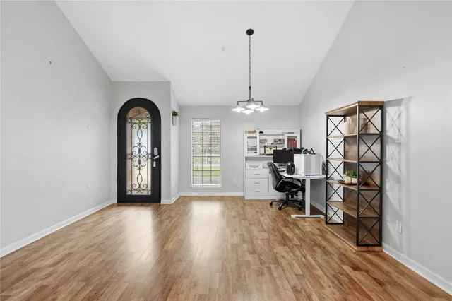 a view of empty room with window and wooden floor