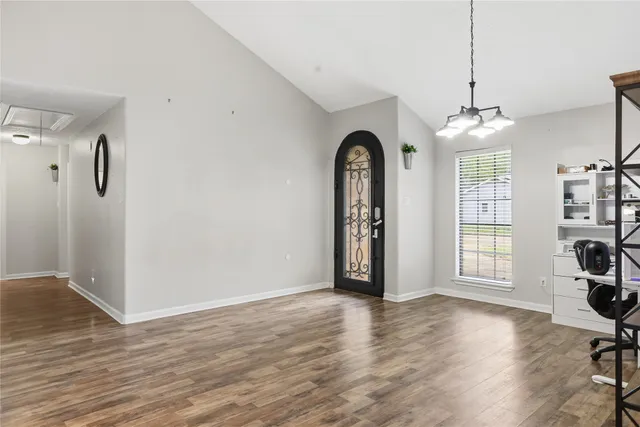 a view of empty room with wooden floor and fireplace