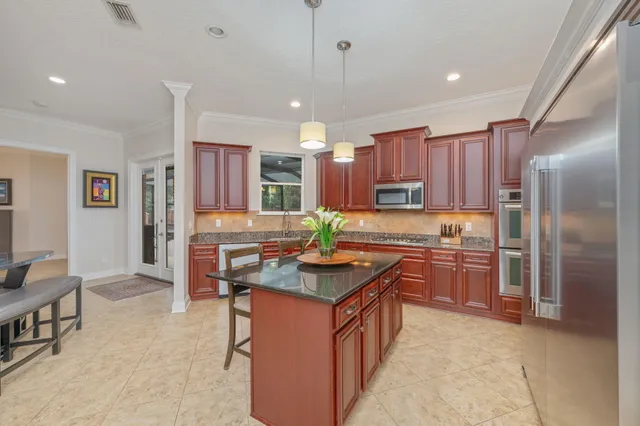 a kitchen with stainless steel appliances granite countertop wooden cabinets a sink and dishwasher a stove top oven with wooden floor