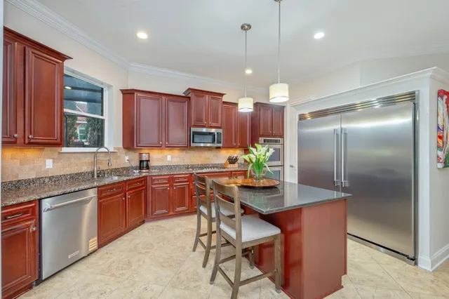 a kitchen with granite countertop cabinets stainless steel appliances and a counter space