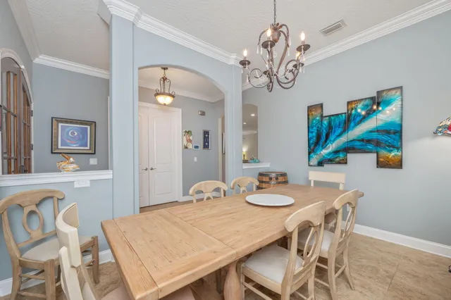 a kitchen with stainless steel appliances granite countertop a refrigerator a sink a stove a dining table and chairs